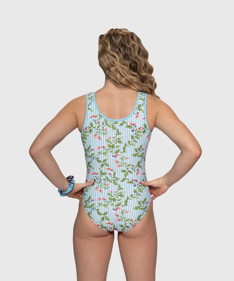Back view of gymnast in Berry Bliss gymnastics leotard with blue stripe accents and berry floral pattern while training.