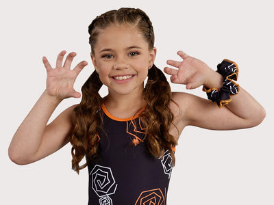 Plum Doodle Gymnastics Unitard for Girls in black, orange, and white. Girls Gymnastics Leotard with Halloween design.