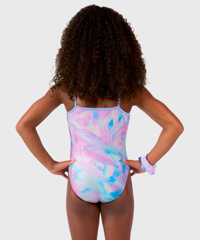 The Plum Ice Prism Leotard features pastel shades of pink, white, grey, and purple with spaghetti straps for freedom of movement. Made from breathable fabrics and smooth seams. Includes a matching scrunchie. 