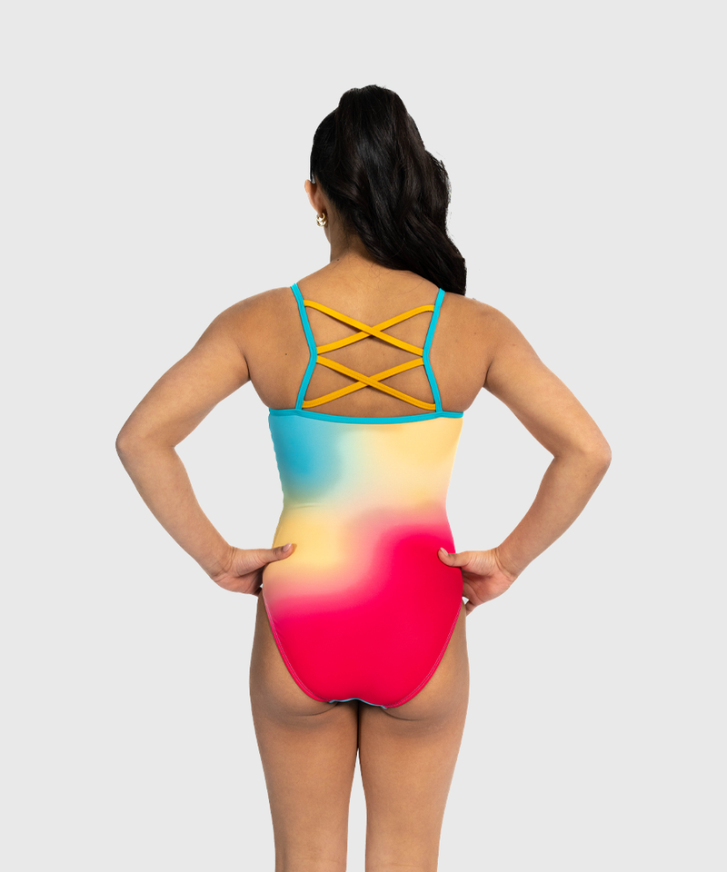 Girls coral shimmer leotard with criss-cross straps. Bold and radiant gymnastics tank.