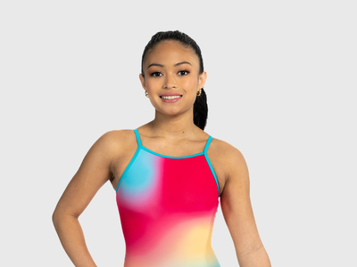 Girls coral shimmer leotard with criss-cross straps. Bold and radiant gymnastics tank.