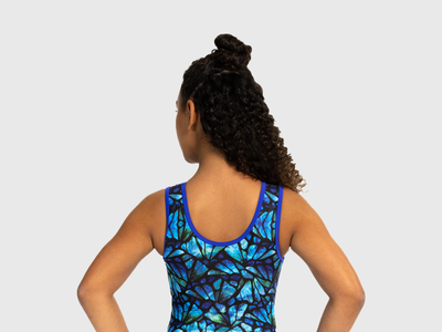 Girls gymnastics leotard with black front and swirling teal, green, and purple back. Flip Side style.