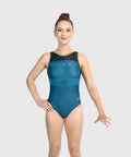 A female gymnast modeling a sleeveless leotard in a studio setting. The leotard is primarily teal blue with a black lace pattern across the chest, a thin gold trim at the neckline, and a small gold letter 'P' on the hip.