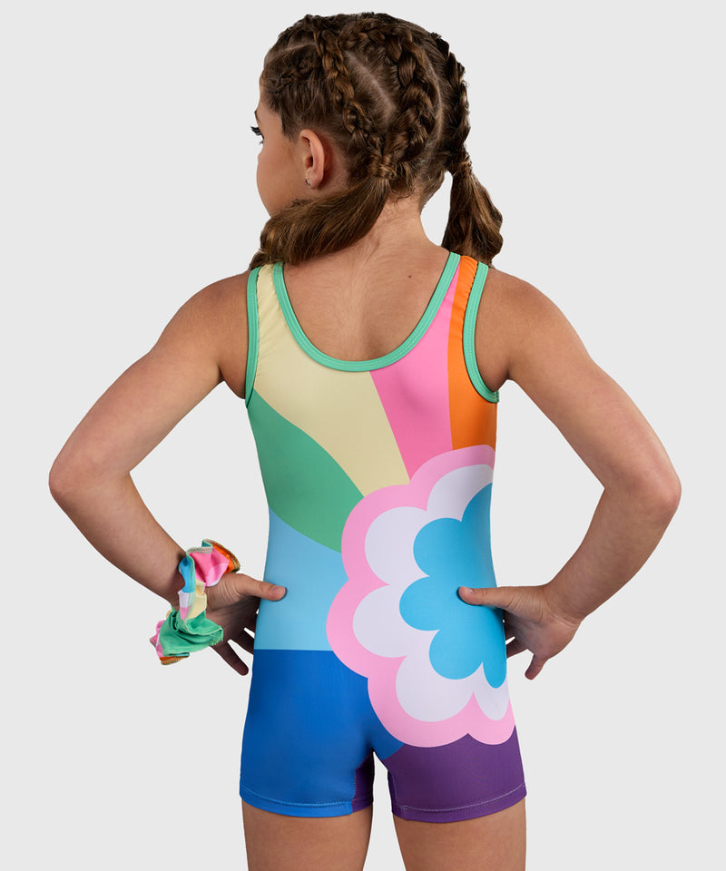 Gymnast wearing the Plum Sprinkles Unitard, a colorful retro gymnastics unitard with a bold rainbow and flower design. 