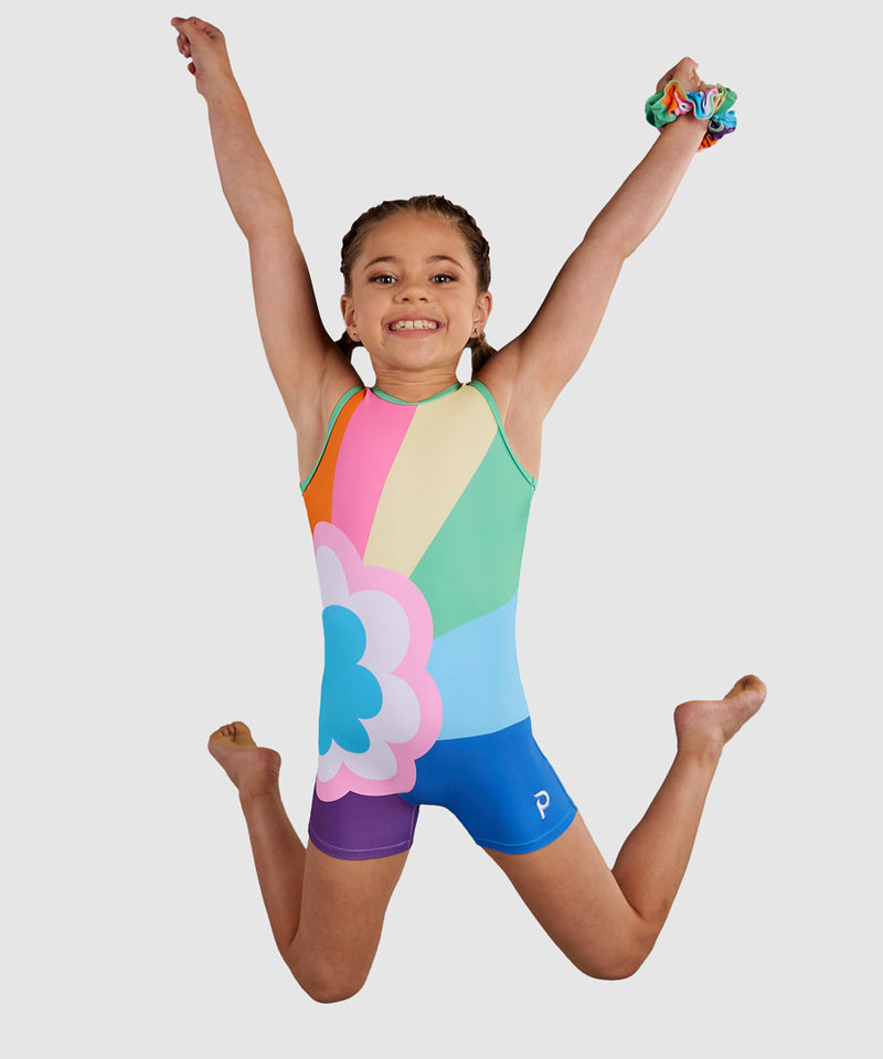 Gymnast wearing the Plum Sprinkles Unitard, a colorful retro gymnastics unitard with a bold rainbow and flower design. 