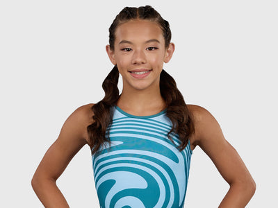 Gymnast wearing the Plum Swirly Unitard, a teal and blue swirl gymnastics unitard with a full-coverage short fit.