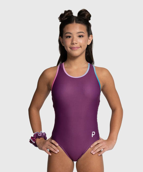 Girl wearing a purple leotard with a white background
